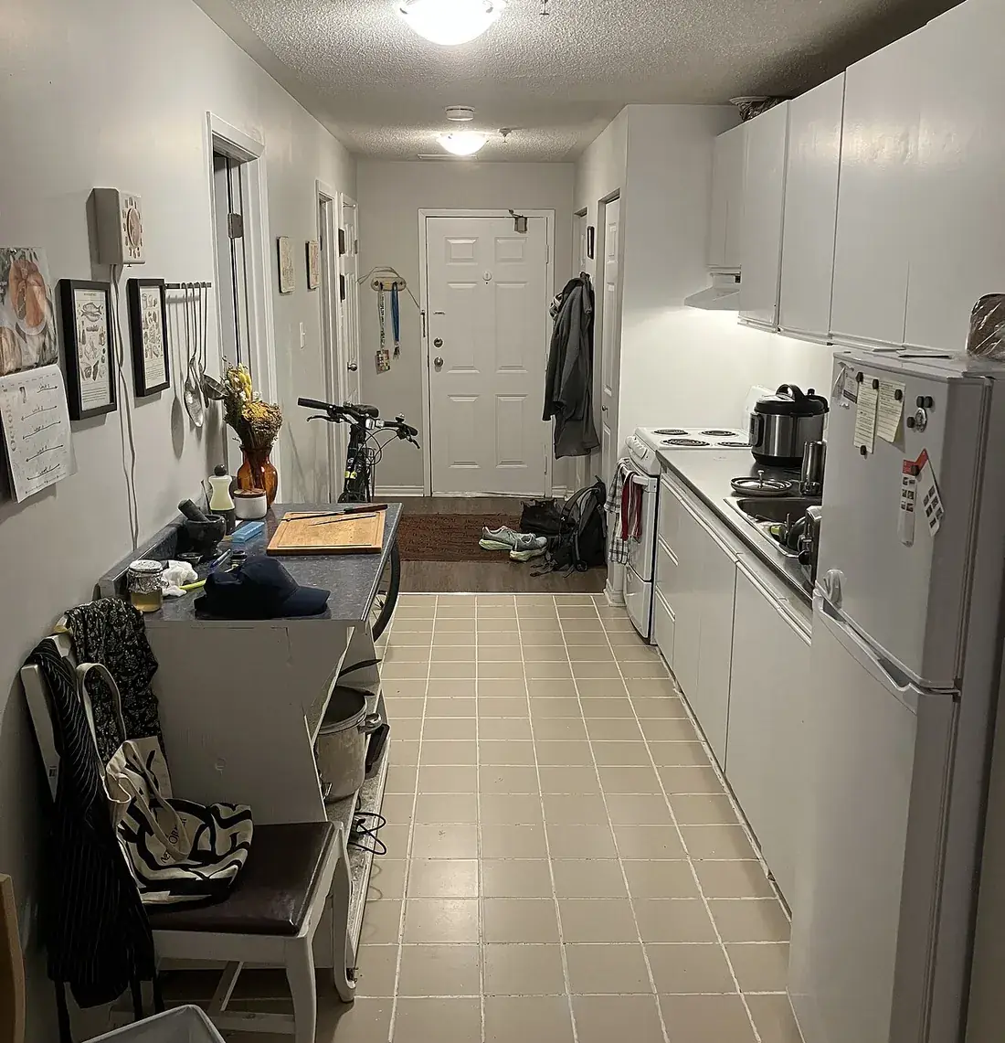 Cocina estrecha con nevera y enseres acumulados, en una vivienda como las que vaciamos en Sant Martí